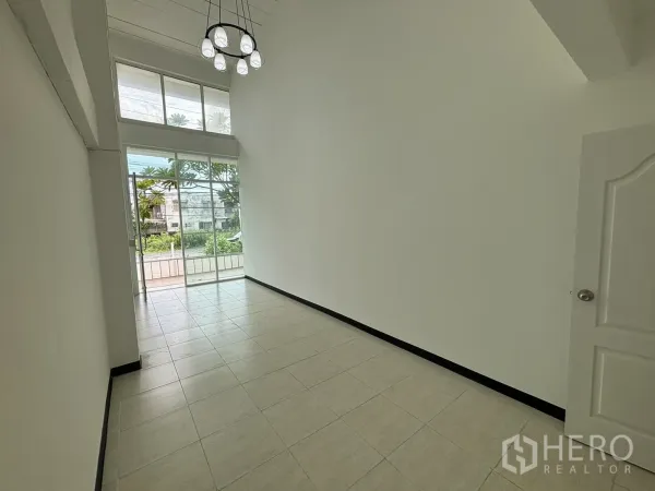带办公室的家 出租在Phra Khanong, Bangkok - 双层挑高入口空间，落地玻璃、吊灯与瓷砖地面。
