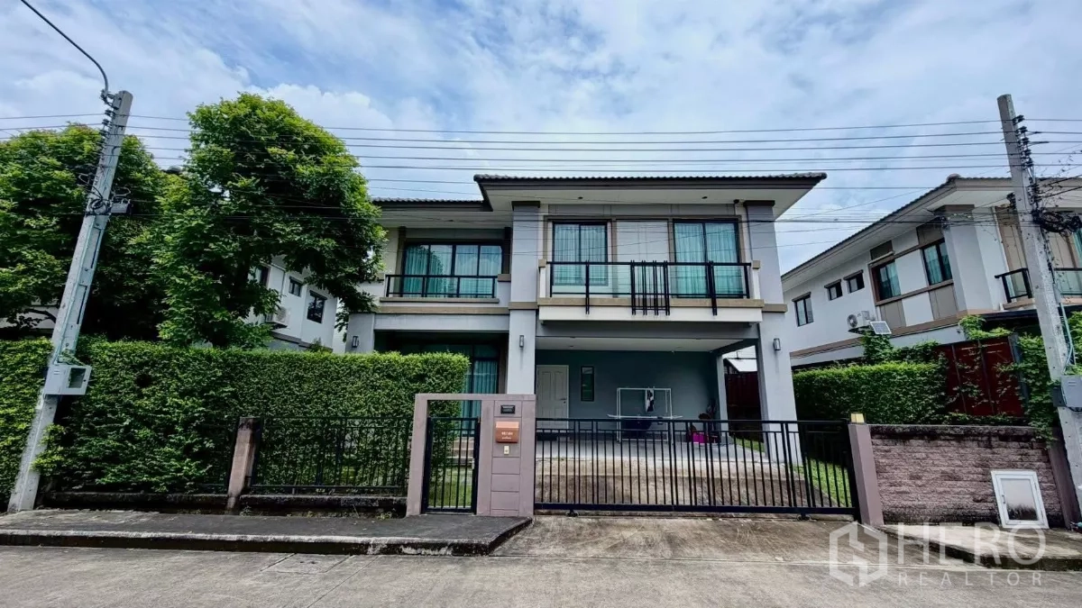 บ้าน ให้เช่าหรือขายในBang Phli, Samut Prakan - มุมมองหน้าบ้านเดี่ยว 2 ชั้น พร้อมรั้วและโรงจอดรถ มีแนวรั้วต้นไม้ในบางพลี