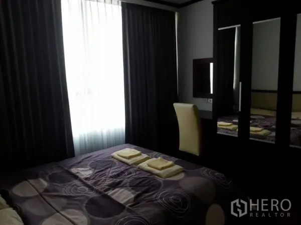 公寓 出租或出售在Pathum Wan, Bangkok - 卧室配深色窗帘、整洁床铺与镜面衣柜，氛围温馨。