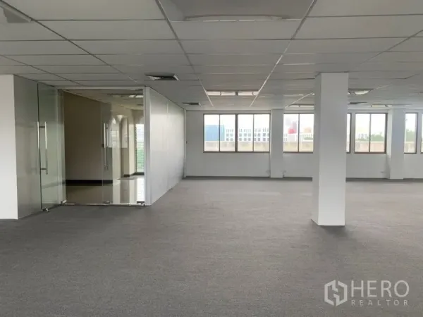 Office Space for rent in Ratchathewi, Bangkok - Bright open-plan office floor with carpet tiles, grid ceiling, and a glass-partitioned meeting room beside large windows.