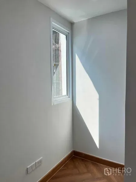 Townhouse for sale in Phra Khanong, Bangkok - Bright corner with a single window casting light onto wood-look flooring.