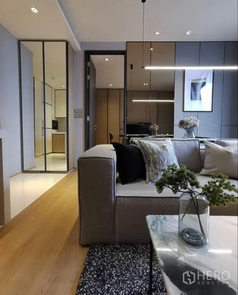 Condominium for rent in Khlong Toei, Bangkok - Cozy sofa corner with marble coffee table and hallway toward kitchen