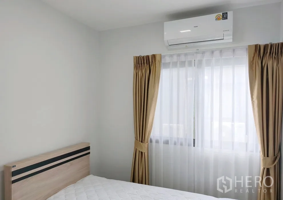 联排别墅 for rent in Bang Phli, Samut Prakan - 卧室内有床、窗帘与墙挂空调。
