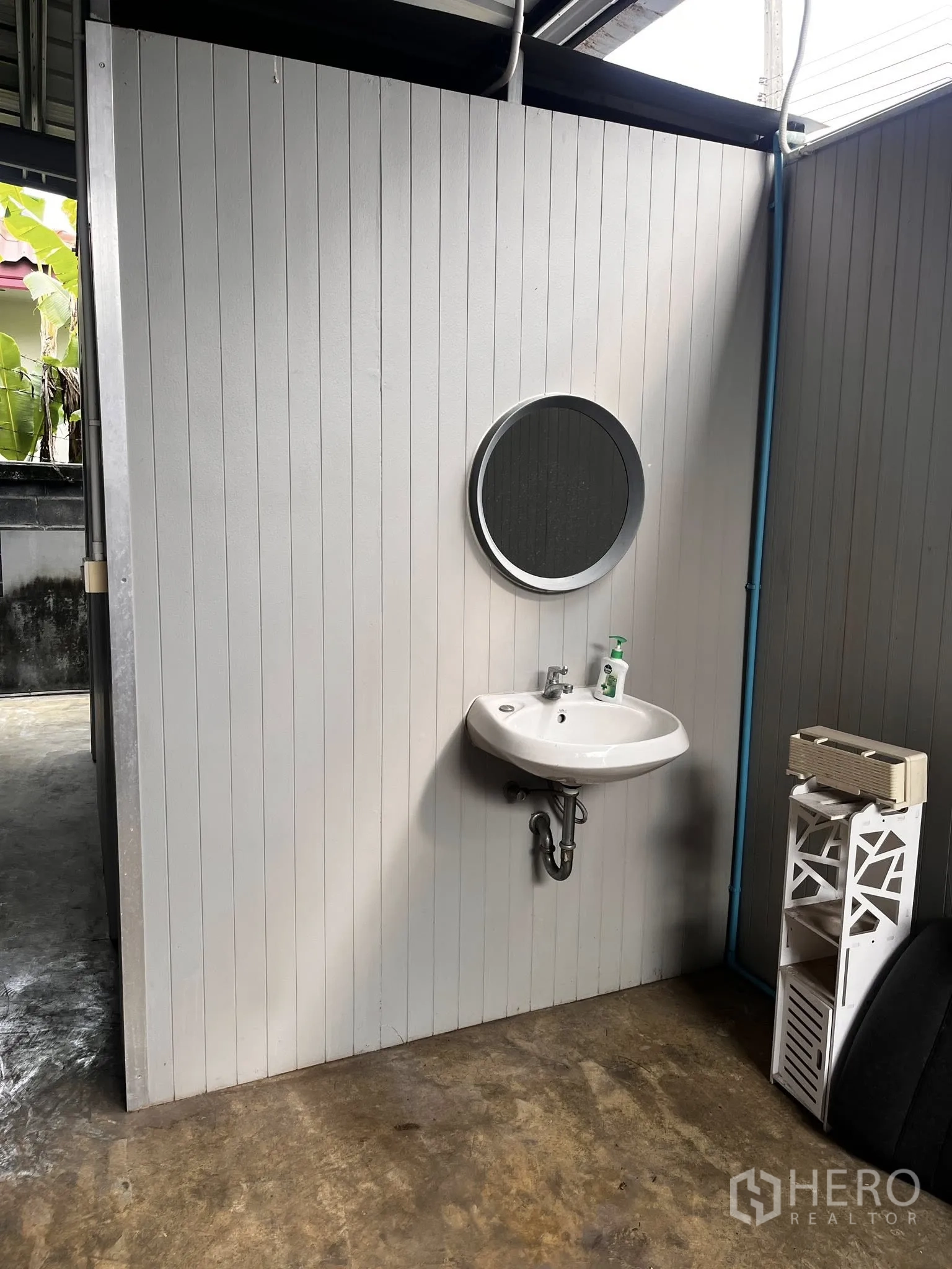 Warehouse for rent in Lat Phrao, Bangkok - Utility area with a wall-mounted handwashing sink and small shelving.