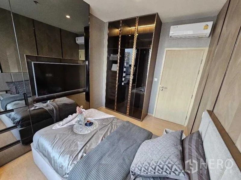 Condominium for rent - Second bedroom with mirrored wardrobe and wall-mounted TV.