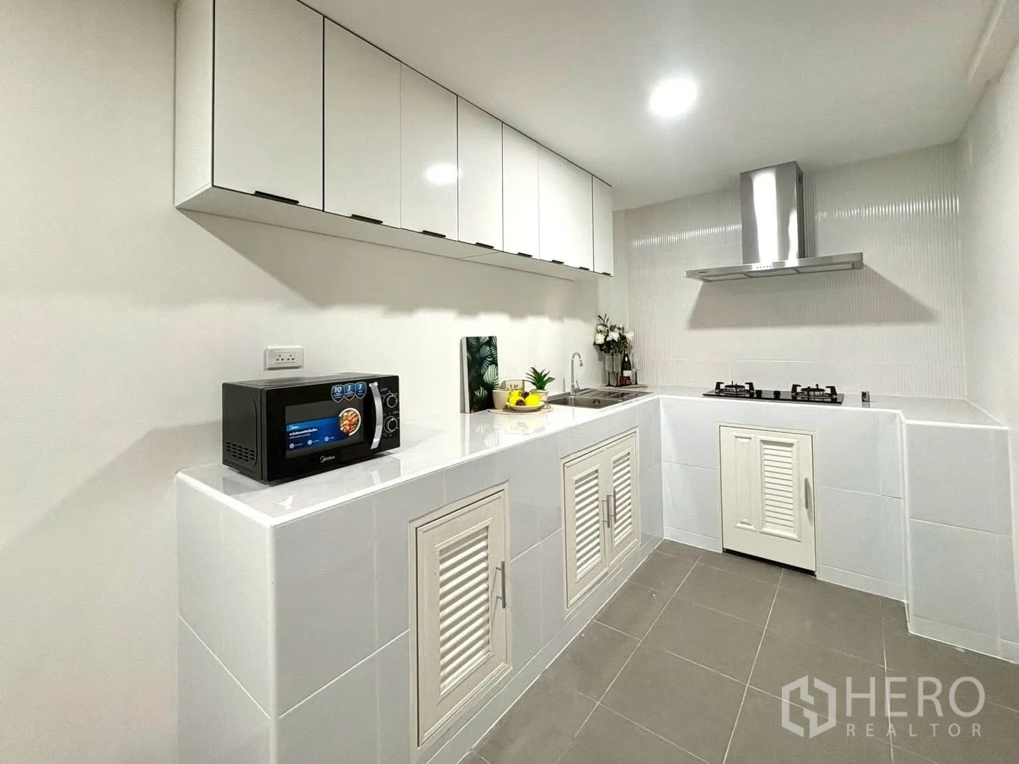 ทาวน์เฮาส์ for rent in Huai Khwang, Bangkok - ครัวโทนขาว ตู้บิวท์อิน อ่างล้างจาน ไมโครเวฟ และเตาแก๊สพร้อมฮู้ด