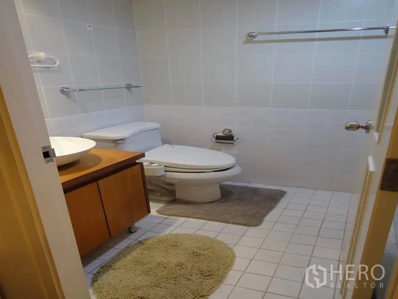 Condominium for rent in Watthana, Bangkok - Guest bathroom with vessel sink, wooden vanity and toilet.
