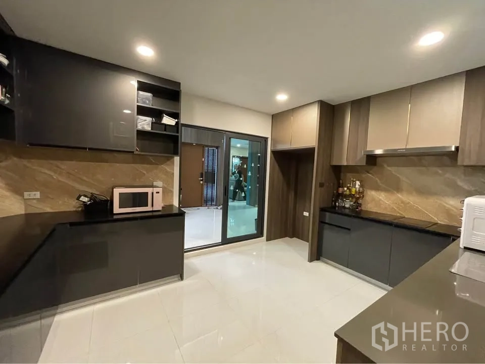 独栋房屋 for rent or sale in Bang Phli, Samut Prakan - 封闭式厨房，深色橱柜、石材背板与抽油烟机。