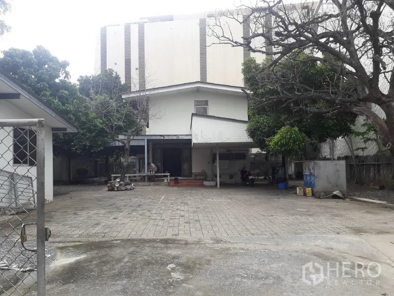 Detached House for rent in Watthana, Bangkok - Gated front yard with ample parking area and mature trees.