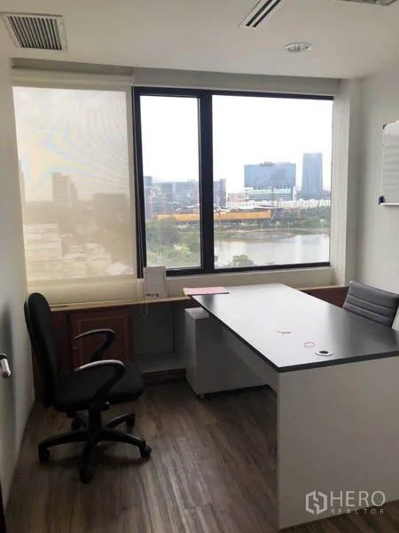 Office Space for sale in Watthana, Bangkok - Private corner office with desk and chair overlooking the city and park-lake view.