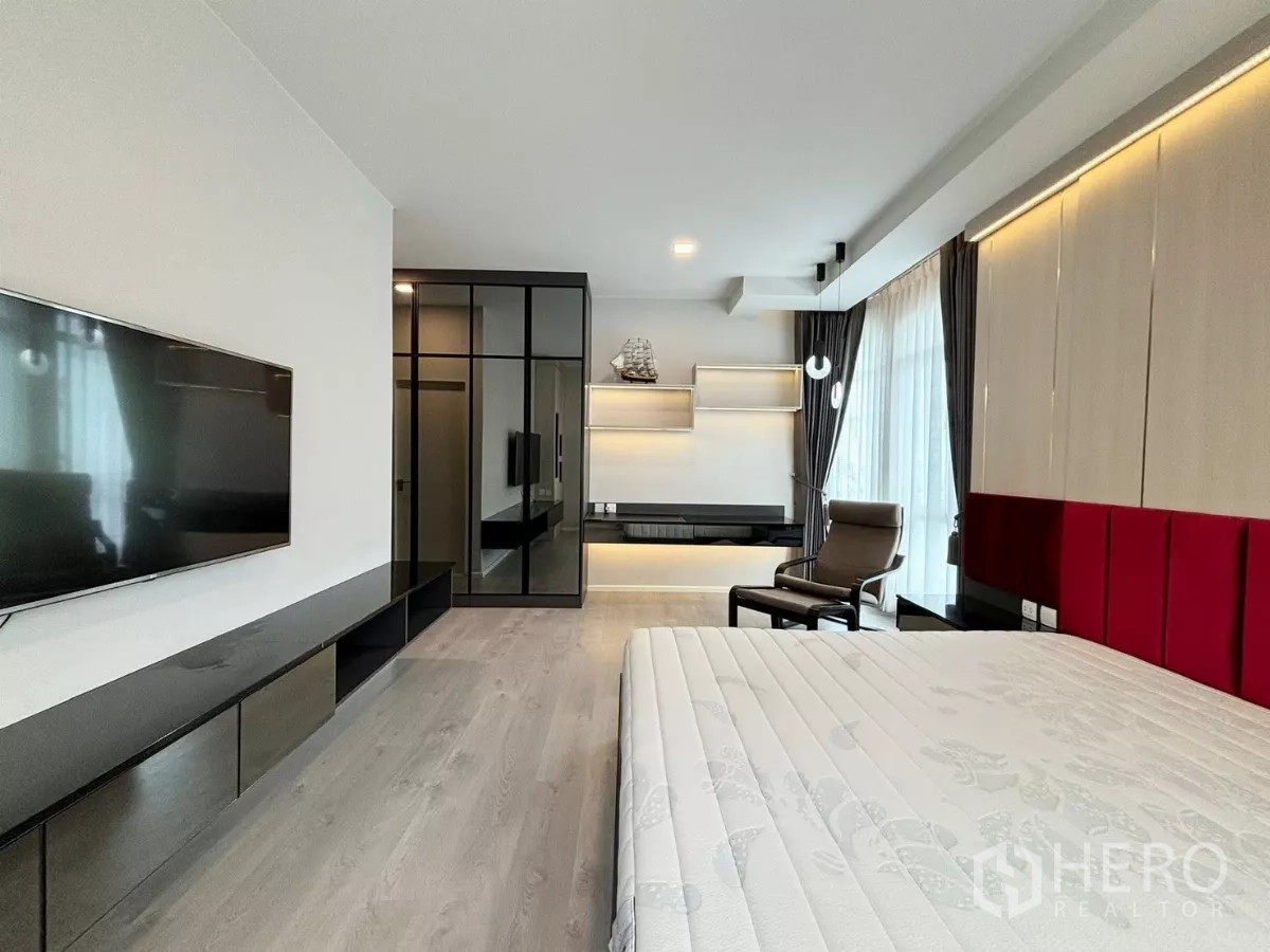 Detached House for rent or sale in Prawet, Bangkok - Bedroom view showing TV wall, mirrored wardrobe and floating shelves with LED lighting.