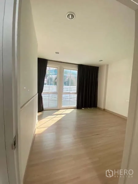 Home Office for rent or sale - Sunlit bedroom with floor-to-ceiling windows and blackout curtains.