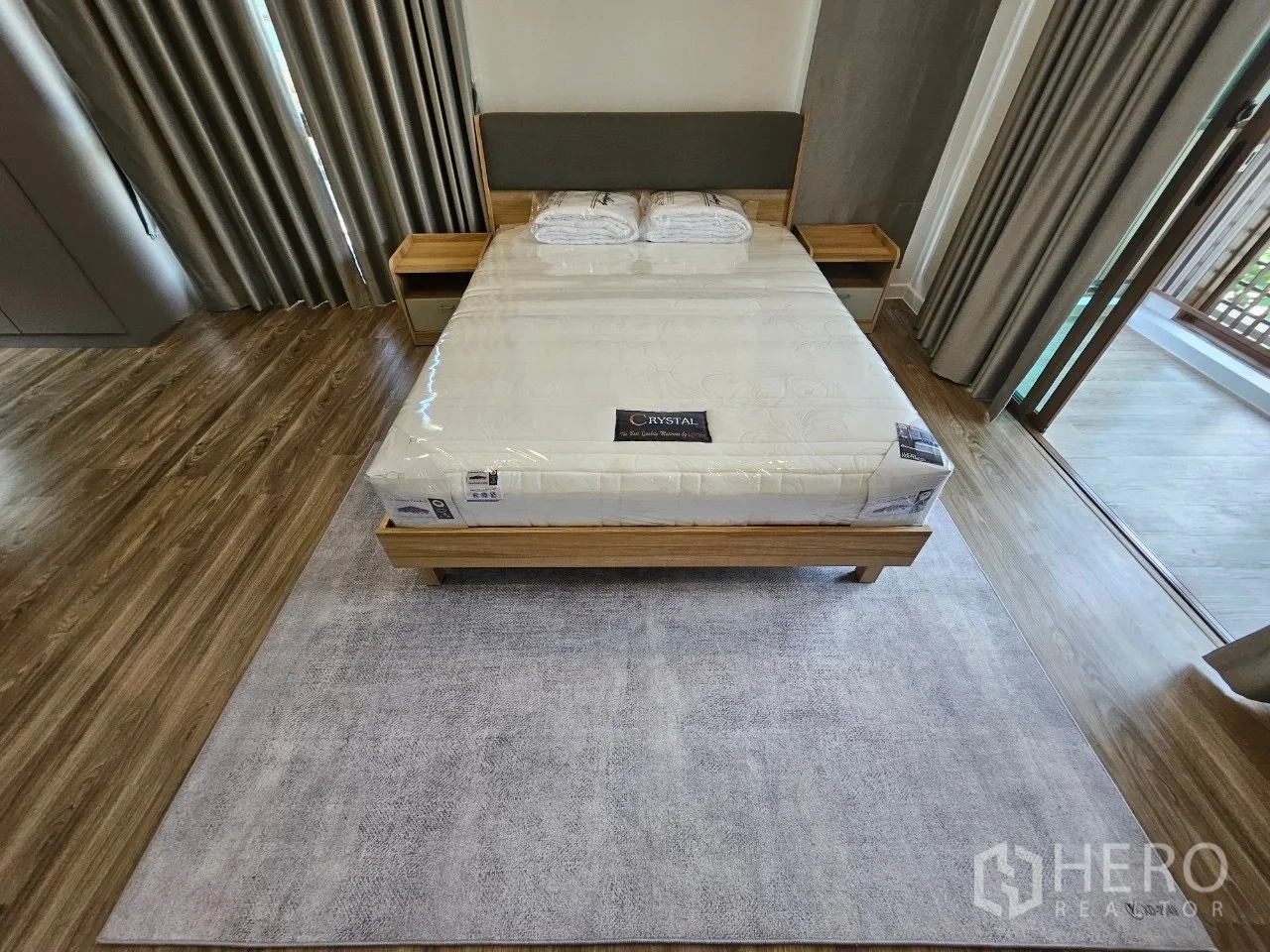 Detached House for rent in Bang Kapi, Bangkok - Master bedroom with queen bed, rug and sliding balcony screen panels.