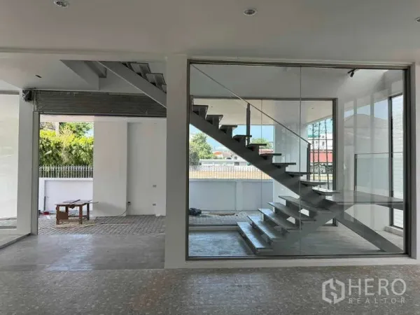 Home Office for rent or sale - Open-plan ground floor with a glass-enclosed floating staircase and large windows.