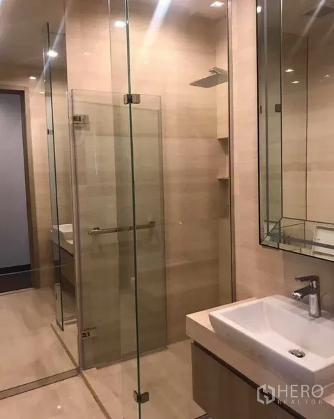 Condominium for rent or sale in Watthana, Bangkok - Contemporary bathroom with glass-enclosed rain shower and square basin.
