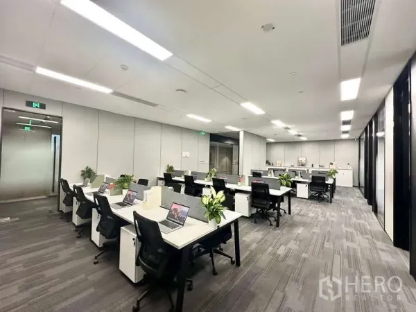 Office Space for rent in Bang Kapi, Bangkok - Wide view of coworking-style desks with ergonomic chairs and carpet tiles in a bright office space.