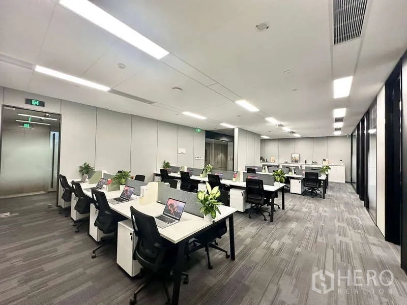 Office Space for rent in Bang Kapi, Bangkok - Wide view of coworking-style desks with ergonomic chairs and carpet tiles in a bright office space.