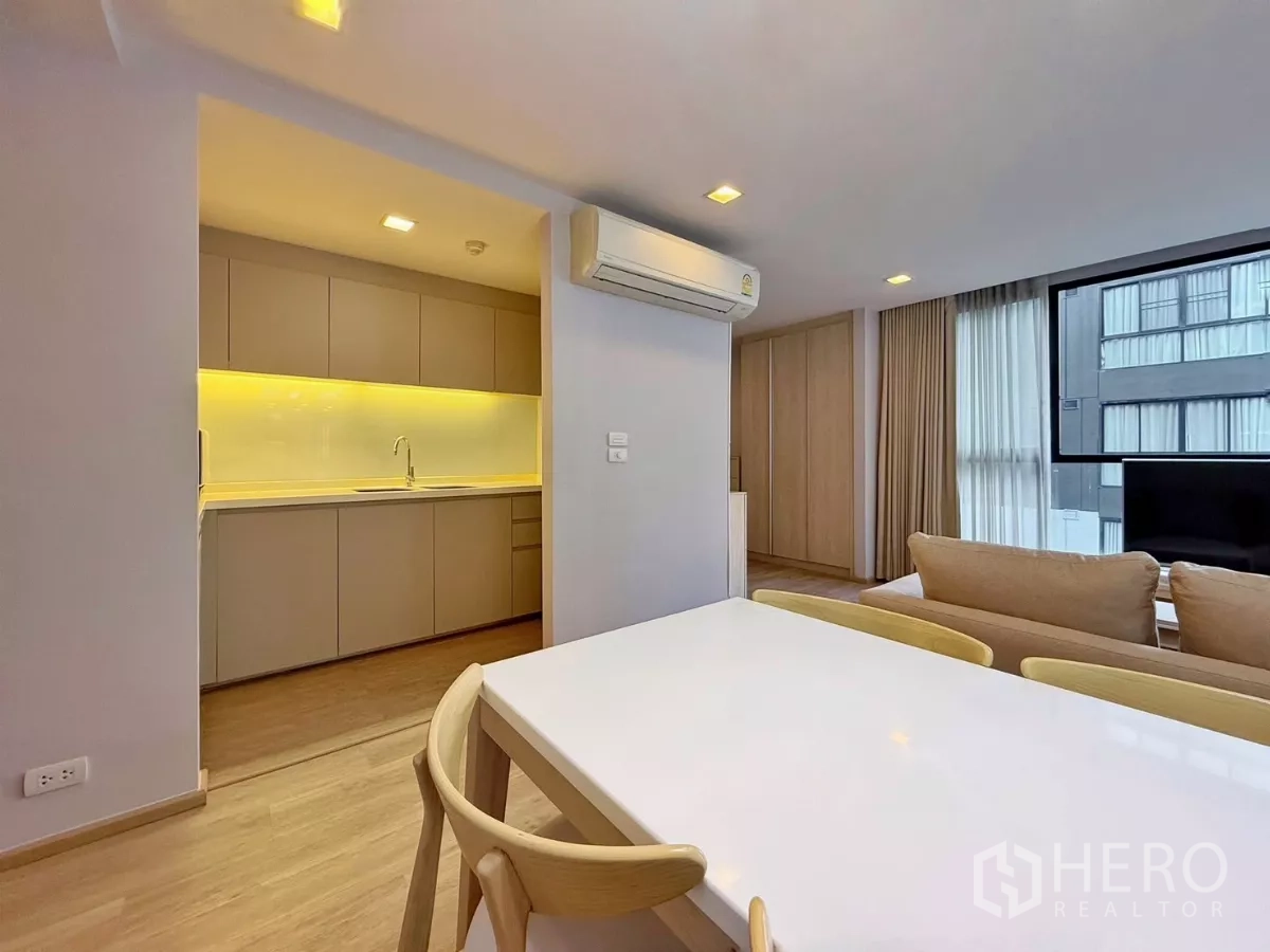 公寓 出租或出售在Watthana, Bangkok - 餐桌近独立厨房入口，墙装空调可见。