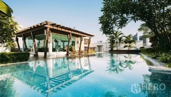 Condominium for rent or sale in Watthana, Bangkok - Rooftop swimming pool with shaded pavilion, greenery and Bangkok skyline views.
