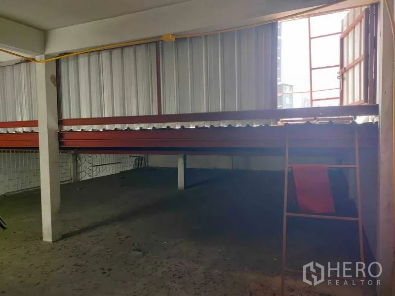 Shophouse for rent in Watthana, Bangkok - Mezzanine area with metal cladding, red steel beams and an open side window.