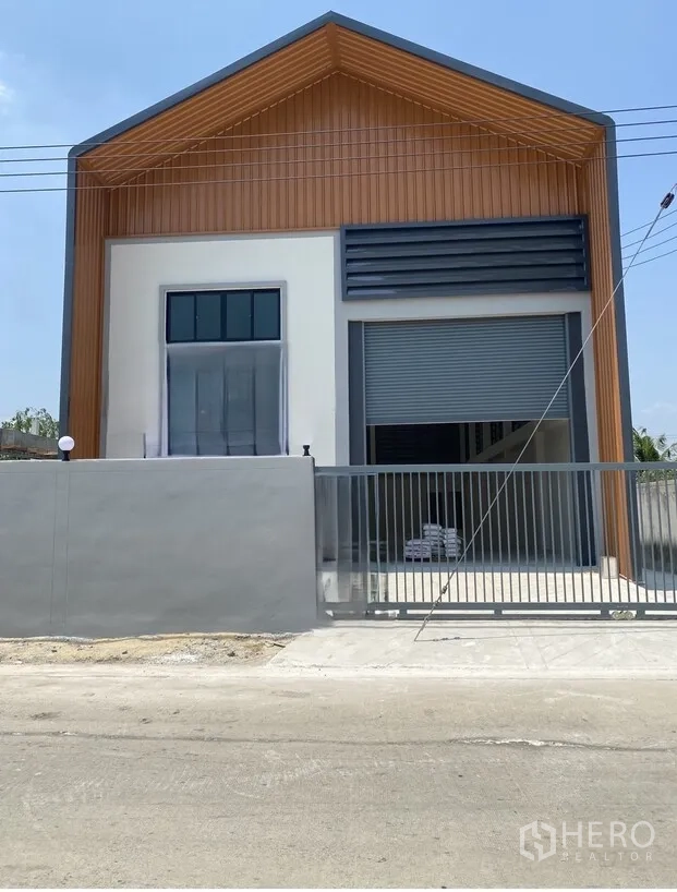 仓库 for rent in Lat Lum Kaeo, Pathum Thani - 现代化仓库外观，设大型卷闸门、前院大门与车道。