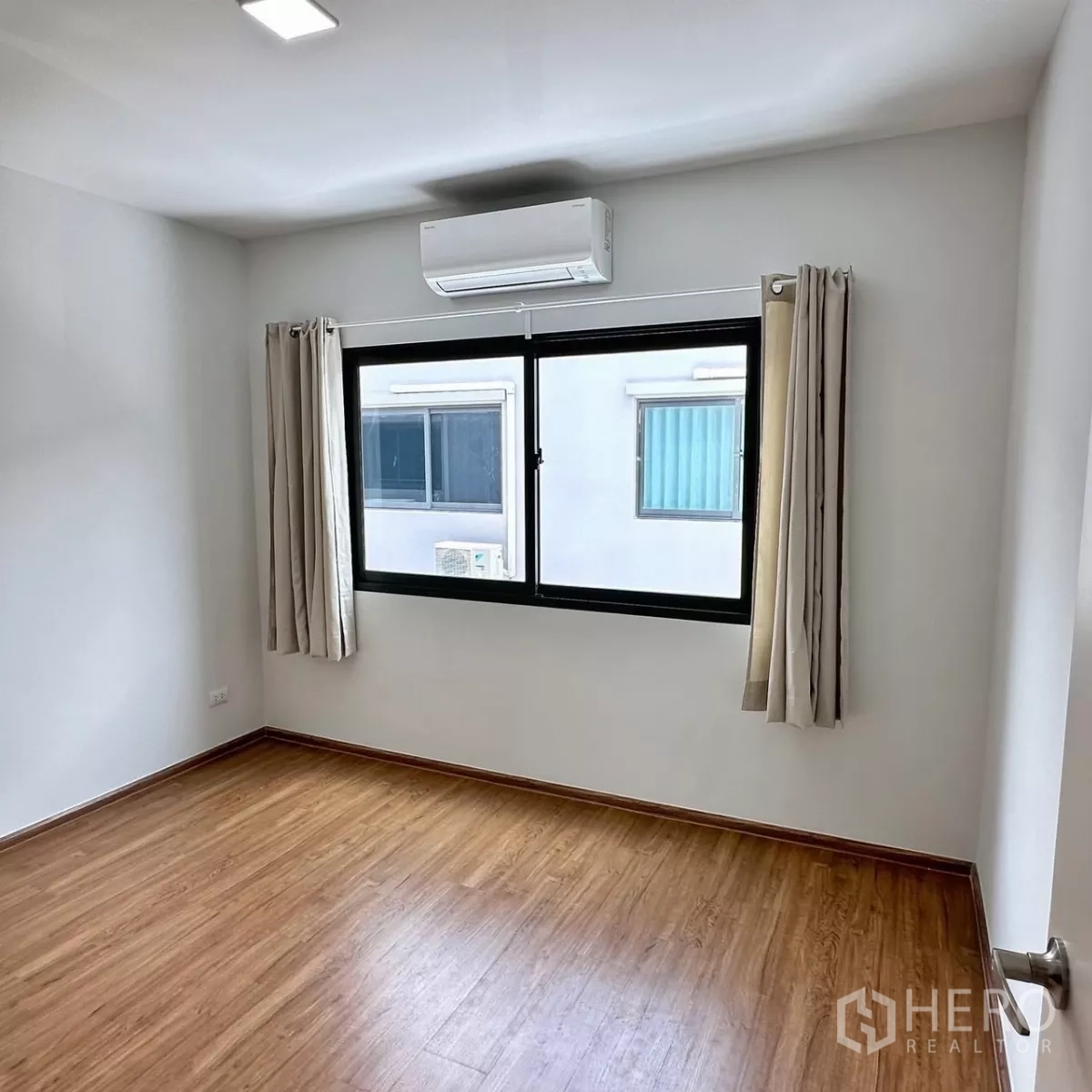 联排别墅 出租在Bang Phli, Samut Prakan - 卧室角落配圆镜梳妆台与高光推拉衣柜。