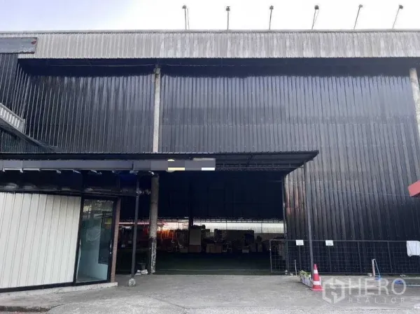 Warehouse for rent in Lat Phrao, Bangkok - Facade of the black corrugated-metal warehouse with a wide entrance.
