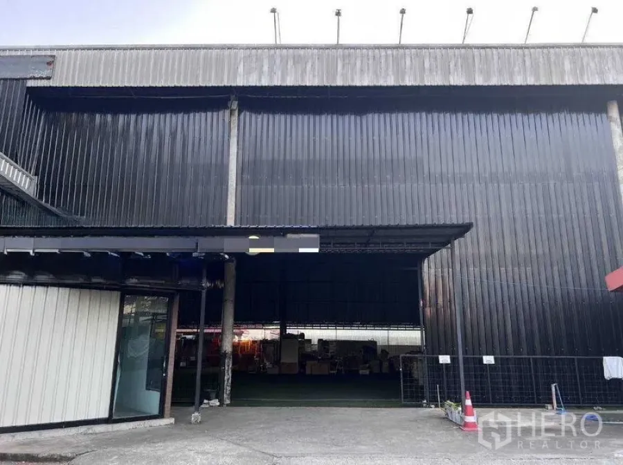 货栈 出租在Lat Phrao, Bangkok - 黑色波纹金属外墙的仓库立面，入口开口宽大。