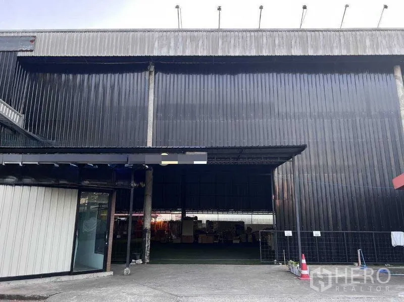 货栈 出租在Lat Phrao, Bangkok - 黑色波纹金属外墙的仓库立面，入口开口宽大。