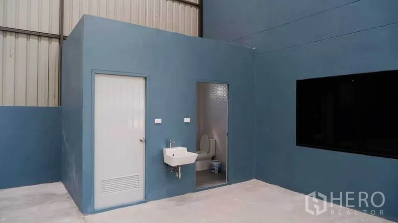 Warehouse for rent in Bueng Kum, Bangkok - Ground-floor restroom block with sink and toilet inside the warehouse.