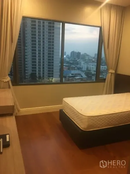 Condominium for rent in Khlong Toei, Bangkok - Bedroom with large window and skyline view, wood flooring and a single bed frame.
