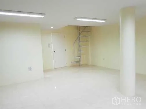 联排别墅 出租在Khlong Toei, Bangkok - 明亮开放式房间，带螺旋楼梯与圆形柱，光亮瓷砖地面。