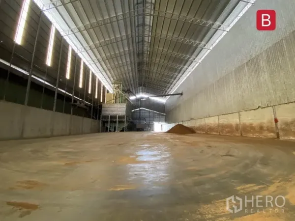 Factory for rent in Chachoengsao - Open production hall with smooth concrete floor and industrial equipment under a tall roof.