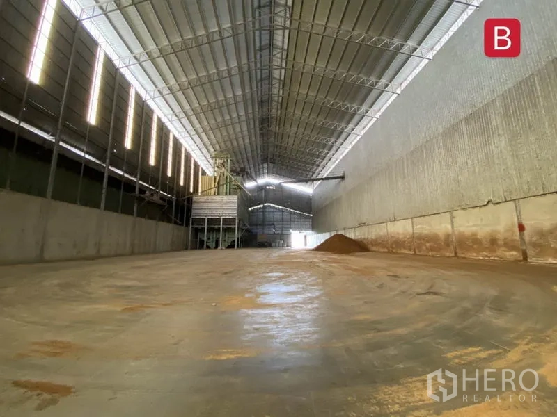 Factory for rent in Chachoengsao - Open production hall with smooth concrete floor and industrial equipment under a tall roof.