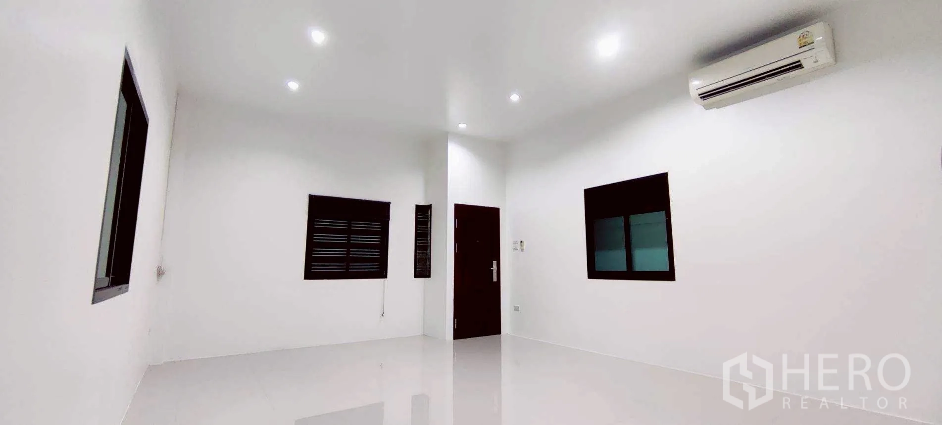 Warehouse for rent in Lam Luk Ka, Pathum Thani - Interior view toward the tall shuttered entrance with natural daylight.