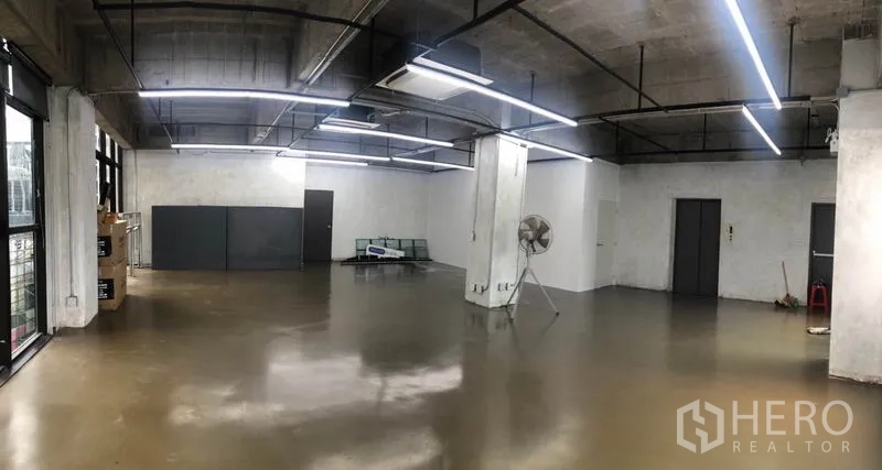 Office Space for rent in Khlong Toei, Bangkok - Panoramic view of empty office space with polished floors, exposed ducting, a support column and multiple access doors