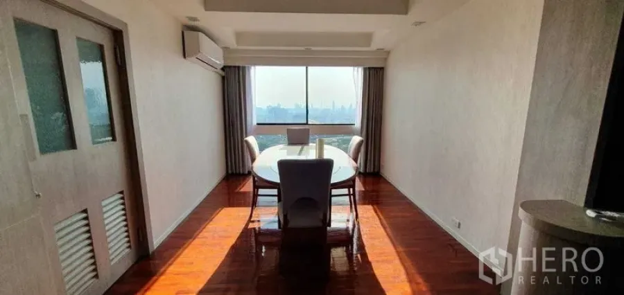 公寓 出租在Khlong Toei, Bangkok - 餐区配大窗，城市天际线景观，木地板与空调。