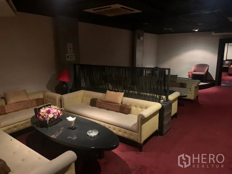 Retail Space for rent in Bang Rak, Bangkok - Carpeted lounge area with cream sofas, an oval coffee table and soft lighting.