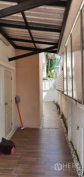 Detached House for sale in Khan Na Yao, Bangkok - Covered side utility corridor with tiled floor and storage room door.