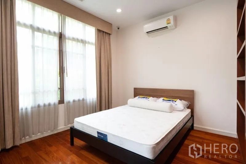 独立式住宅 出租在Watthana, Bangkok - 次卧配大窗、窗帘与挂墙空调。