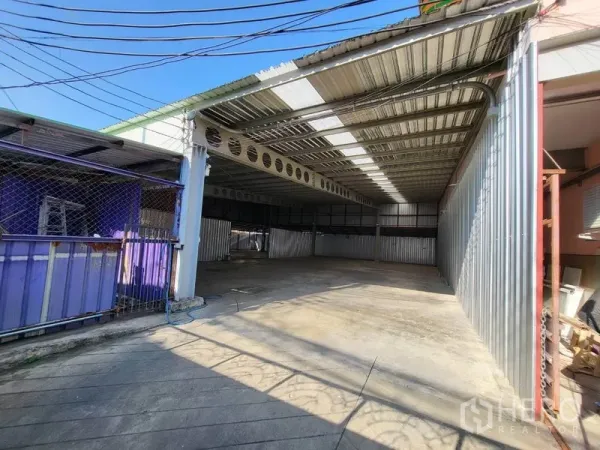 คลังสินค้า ให้เช่าในDin Daeng, Bangkok - ลานหน้าพื้นที่และประตูบานเลื่อนเข้าสู่โกดังมีหลังคาคลุม พื้นคอนกรีต