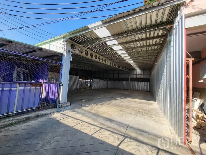 คลังสินค้า ให้เช่าในDin Daeng, Bangkok - ลานหน้าพื้นที่และประตูบานเลื่อนเข้าสู่โกดังมีหลังคาคลุม พื้นคอนกรีต
