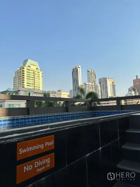 อพาร์ทเมนท์ ให้เช่าในKhlong Toei, Bangkok - ขอบสระพร้อมป้ายห้ามกระโดดน้ำและวิวตึกสูงโดยรอบ