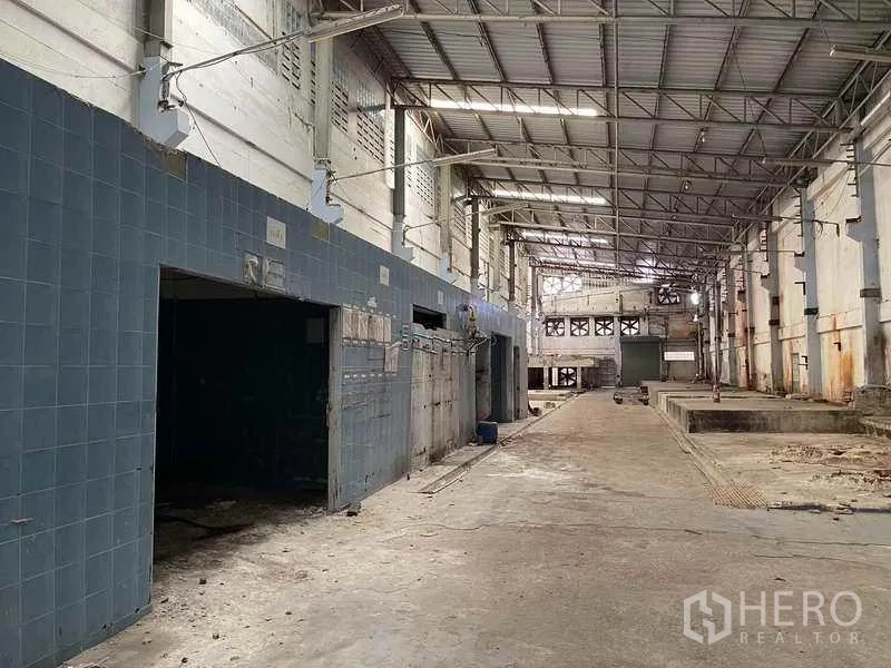 Factory for rent in Phra Samut Chedi, Samut Prakan - High‑bay production hall with steel trusses, tiled service block and loading zones.