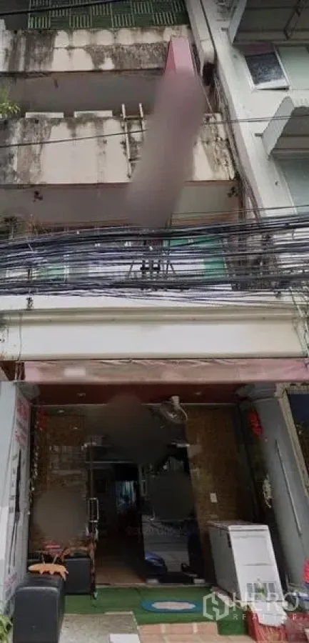 店屋 出租在Watthana, Bangkok - 四层店屋外立面，带阳台，一层店面敞开，门前有电缆，位于曼谷瓦他那区澎蓬一带。
