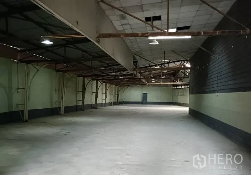货栈 出租在Bang Khen, Bangkok - 深进式开放仓库，钢拱架、吊灯与侧门出入口。