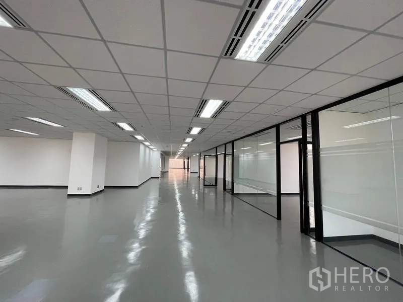 Office Space for rent in Din Daeng, Bangkok - Long office corridor with glass-partitioned meeting rooms and bright ceiling lights.