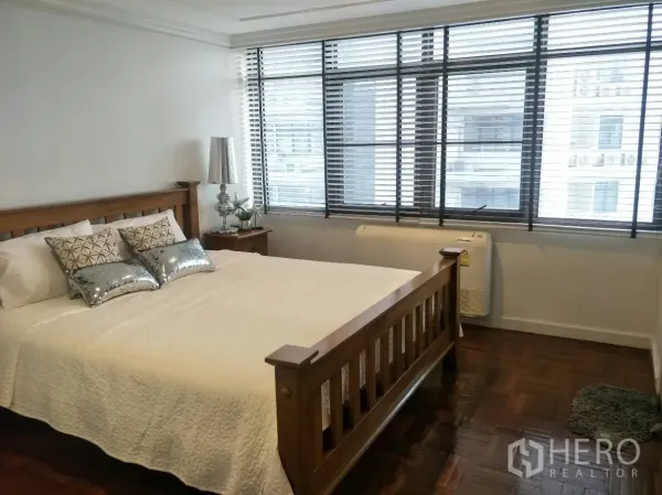 公寓 出租在Watthana, Bangkok - 采光充足的卧室，木质床架、大窗户与人字拼木地板。