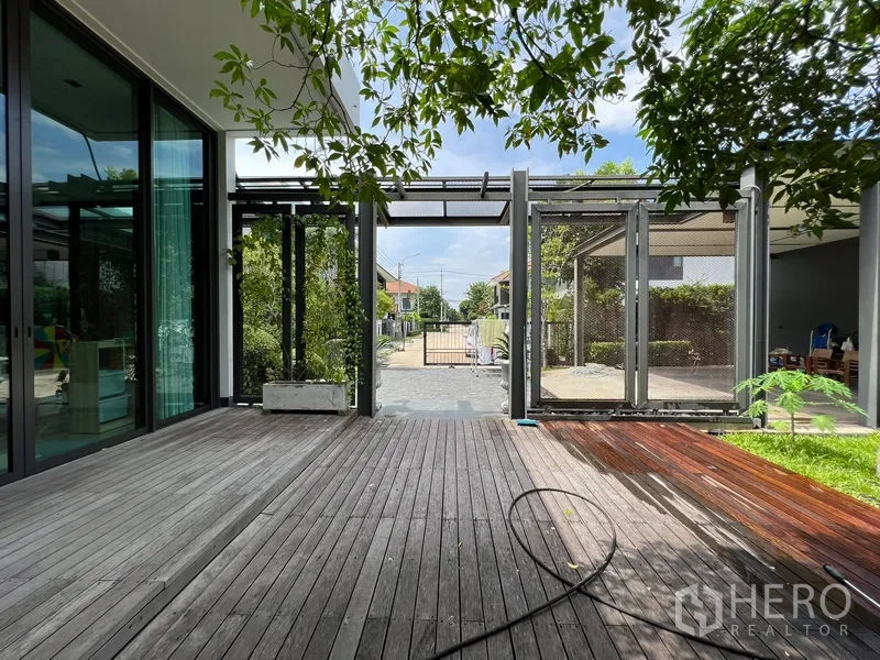 Detached House for sale in Bang Kapi, Bangkok - Wooden deck facing the front gate and paved driveway.