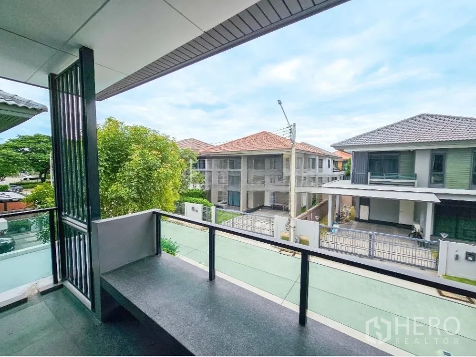 Detached House for sale in Lam Luk Ka, Pathum Thani - Balcony overlooking a peaceful residential street and neighboring houses.